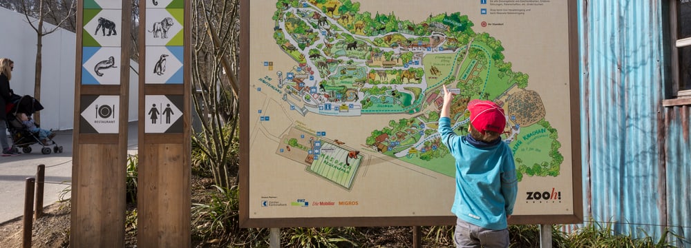 Grosse Tafel des Zooplans mit kleinem Knaben davor.