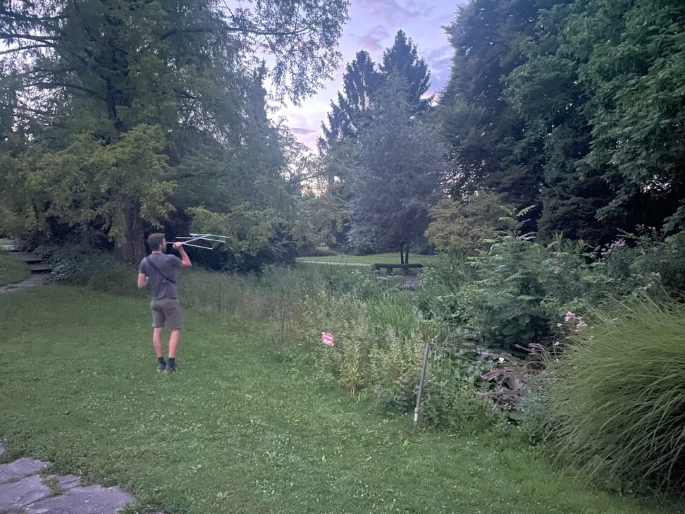 Ein Forscher nimmt mittels Empfänger die Spur einer besenderten Zwergfledermaus auf dem Friedhof Nordheim in Zürich auf.