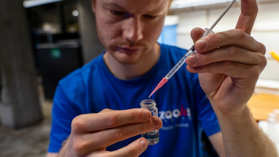 Ein Tierpfleger nimmt eine Probe, um die Wasserqualität zu analysieren.